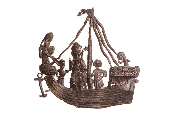 Pewter pilgrim badge of St Thomas Becket standing on a ship. A knight in armour stands at the front of the ship. 2 figures stand next to Becket on the deck and a sailor at the stern.