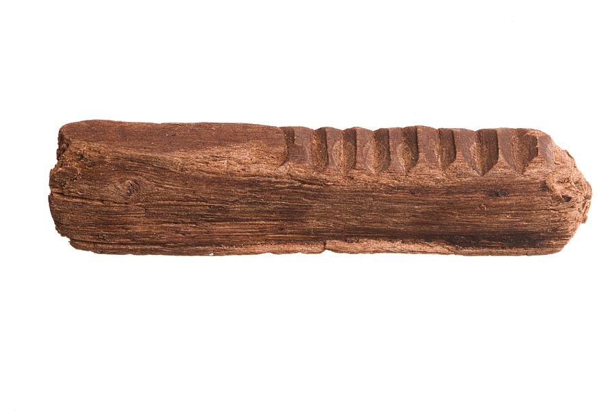 Fragment of a wooden tallystick with 3 deep notches and 4 shallow ones carved into the top.
