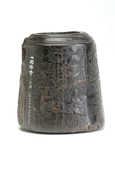 Black inkwell, made from horn. The horn has been pressed so its surface is decorated with tiny figures of saints.