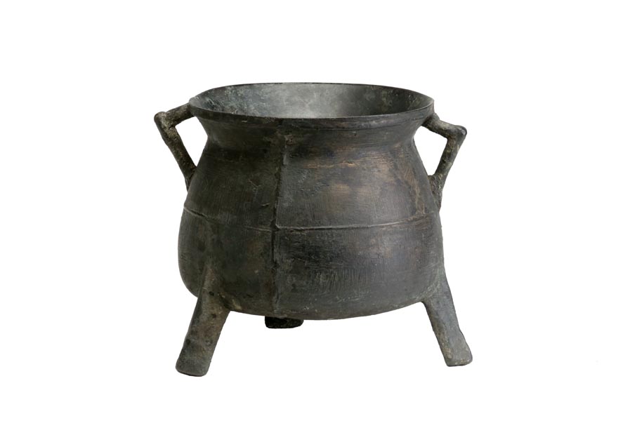 Copper alloy cauldron with 3 feet. There are 2 pointed handles under the rim.