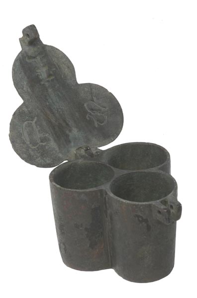 Pewter pot divided into 3 circular parts. The lid is attached on a hinge and is open. The letters 'S.D.I.' are engraved inside the lid.