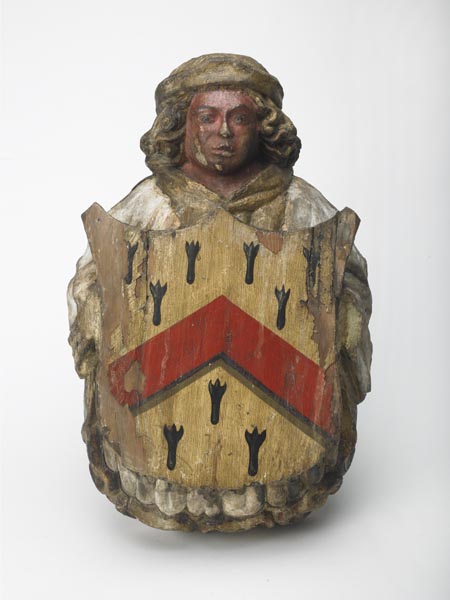 Carved and painted wooden angel holding a shield on which are the arms of the Grocer's Company.