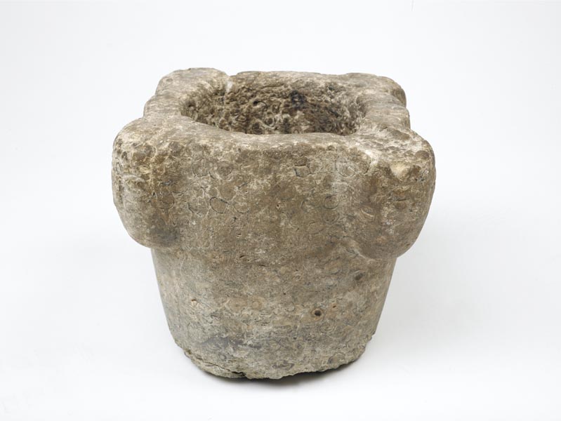 Large, grey stone mortar with 4 projecting bosses around the rim.