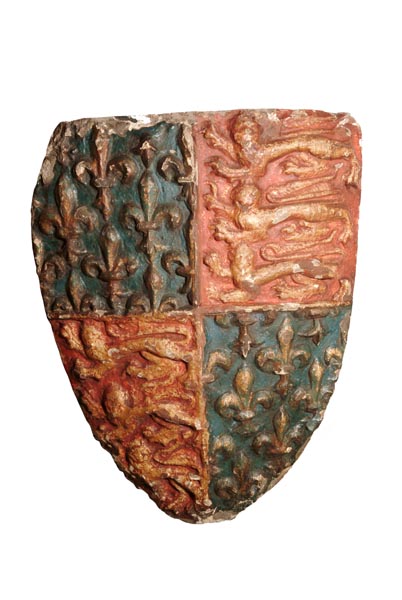 Carved stone shield. The bottom left and top right quarters are painted red and have 3 lions in gold. The bottom right and top left quarters are painted blue and have fleur de lis in gold.