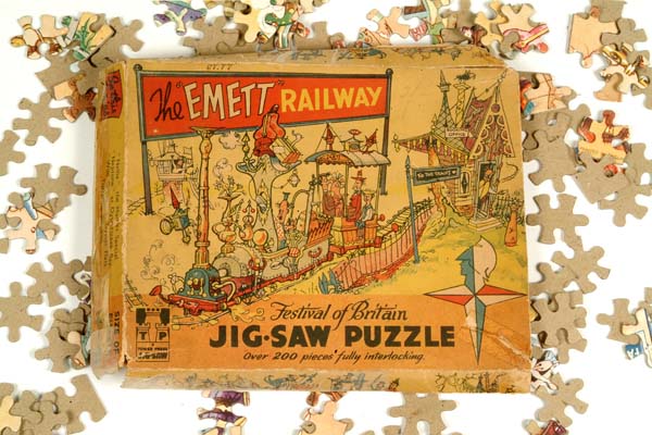 A jigsaw puzzle box with some of the puzzle pieces spread around it