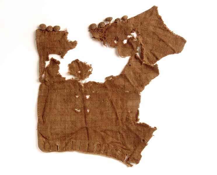 Fragment of woollen sleeve that is open and flat. There are 8 woollen buttons at the top and button holes at the bottom. The wool is discoloured and brown.