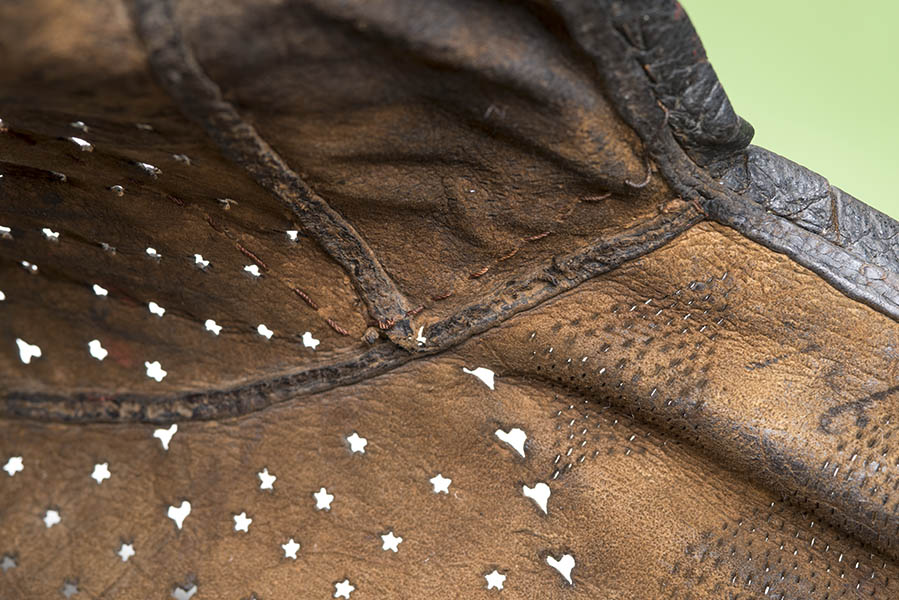 Leather jerkin (a short-sleeved jacket) decorated with slashes and holes cut through the leather.
